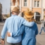 2 older adults hug while on vacation representing the successful outing that can still happen while caring for elderly loved ones.